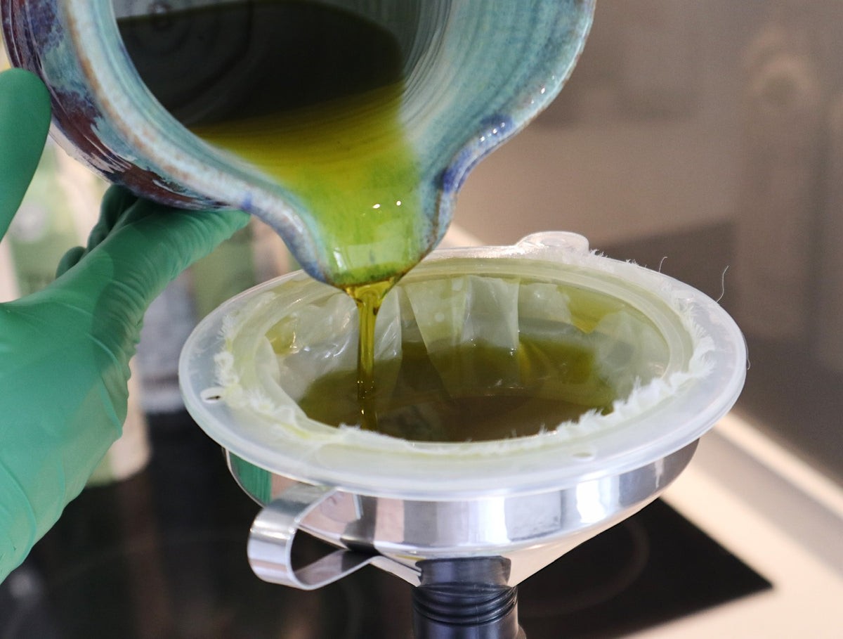 Freshly pressed Trigly olive oil being poured through a filter